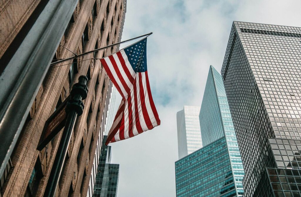 Флаг США на фоне небоскребов Флаг США на фоне небоскребов